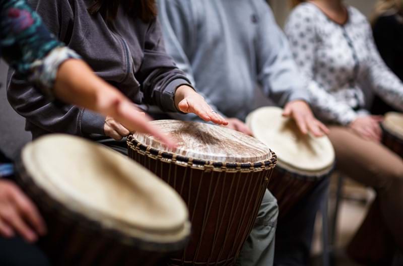 A group of people drumming.